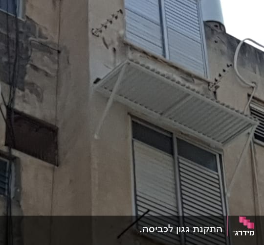 מרפסת אלומיניום עם תריסים סגורים על קיר בניין